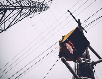 Low angle view of electricity pylon against clear sky