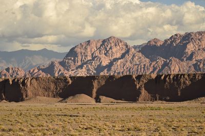 Scenic view of field and mountains against sky