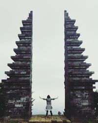 Rear view of man standing at temple against building