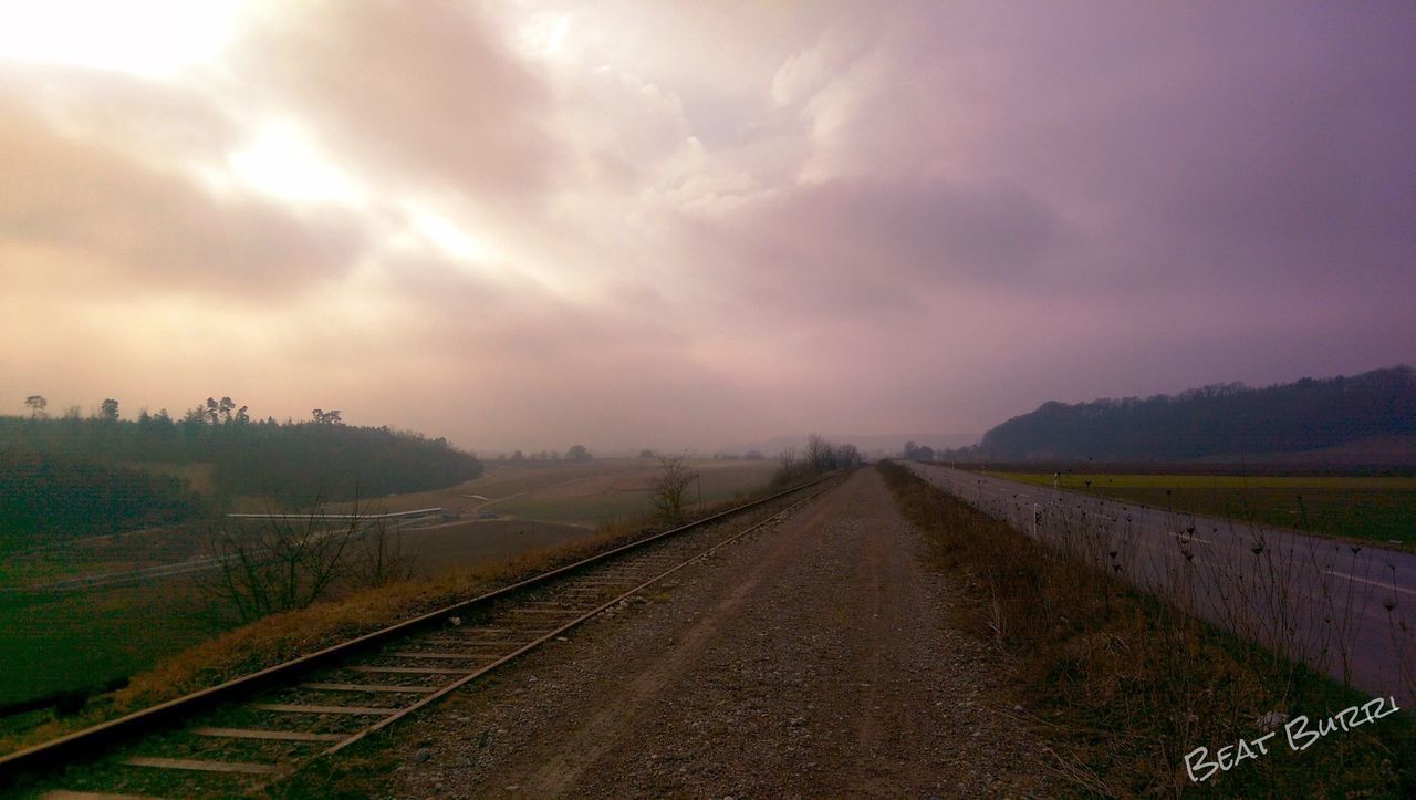 the way forward, diminishing perspective, vanishing point, sky, transportation, landscape, cloud - sky, tranquil scene, tranquility, field, cloudy, road, nature, country road, railroad track, rural scene, scenics, beauty in nature, cloud, dirt road