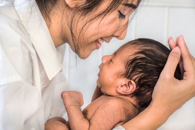 Close-up of woman holding newborn son at home
