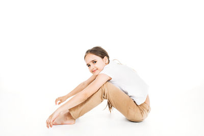 Portrait of woman sitting against white background