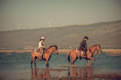 People riding horse in the sea