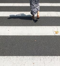 Low section of woman crossing road