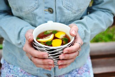 Midsection of woman holding fruit