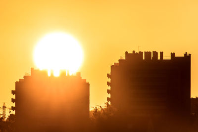 Silhouette buildings against sky during sunset