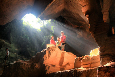 Low angle view of tourists on cliff