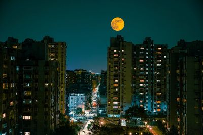 Illuminated cityscape against clear sky at dusk