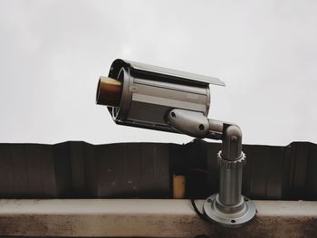 Close-up of coin-operated binoculars on wall against clear sky