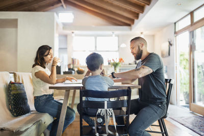 Family of three sitting at dining table in house