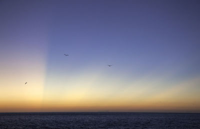 Scenic view of sea against clear sky during sunset