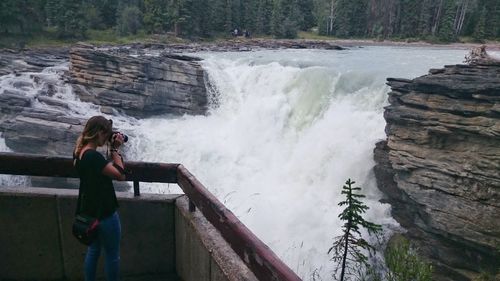 Rear view of woman looking at waterfall