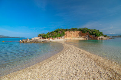 Scenic view of beach against blue sky