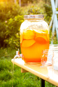 Orange juice flowing from jar in back yard