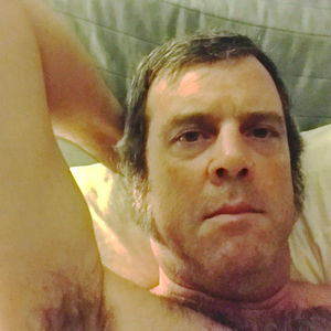 Close-up portrait of man relaxing on bed at home