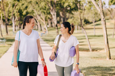 Portrait of smiling friends standing in park