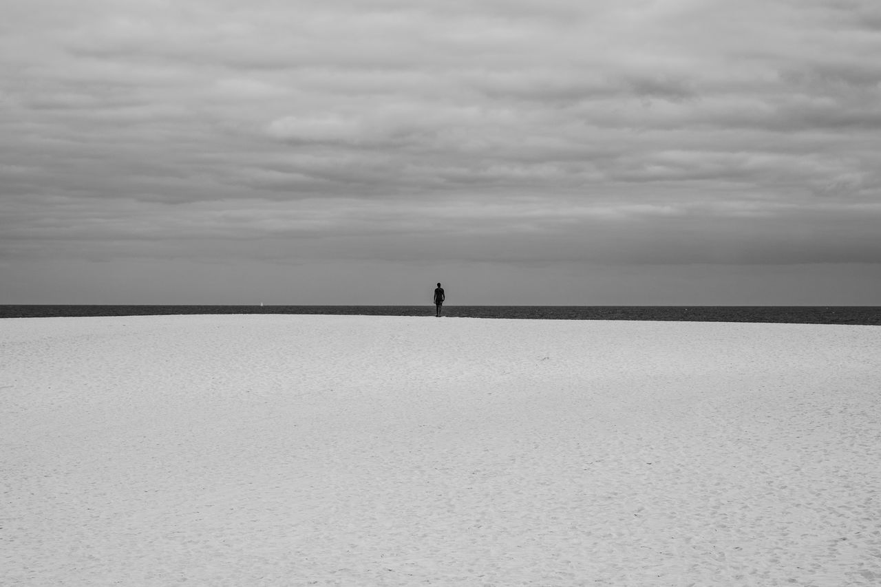 sky, cloud - sky, scenics - nature, beauty in nature, horizon, sea, one person, tranquil scene, tranquility, horizon over water, nature, water, land, real people, unrecognizable person, standing, day, non-urban scene, outdoors, salt flat