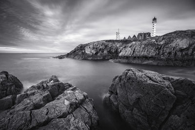 Rocks by sea against sky