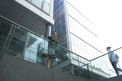 People on staircase by building in city