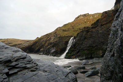 Scenic view of waterfall against sky