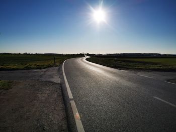 Road passing through landscape against clear sky