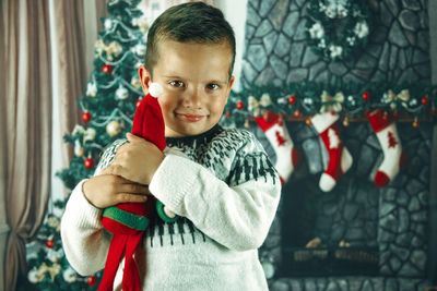 Portrait of cute boy standing at home during christmas