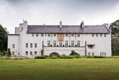 Lawn in front of building against sky