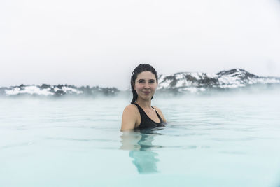 Portrait of smiling young woman in hot spring