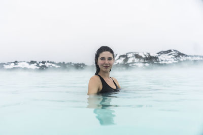Portrait of smiling young woman swimming in pool
