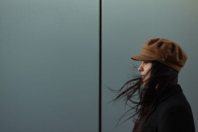 Rear view of woman standing against wall