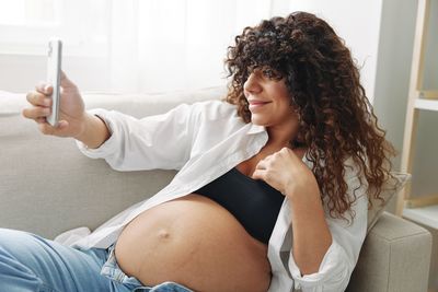 Young woman using mobile phone at home