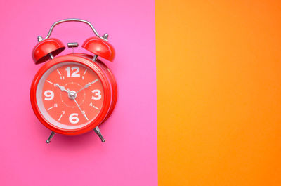 Close-up of clock on pink background