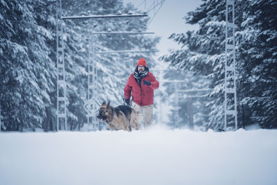 Person with dog in snow during winter