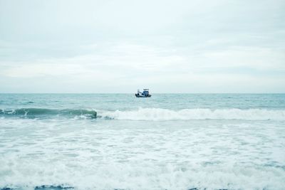 Boat sailing in sea against sky