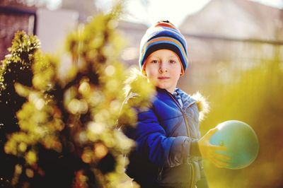 Portrait of cute girl with balloon standing in park