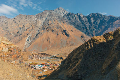 Stepantsminda, kazbegi, goergia. cityscape of big rural town with mountain range of mount kazbak.