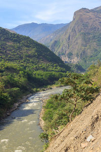 Scenic view of road by mountains against sky