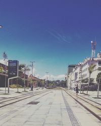 Street amidst buildings against blue sky