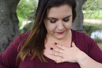 Close-up of young woman with hand on chest