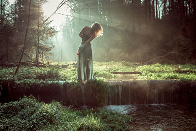 Woman standing in forest