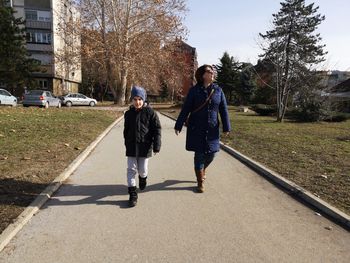 Mother and son walking in city
