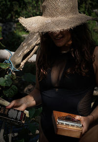 Midsection of woman holding book outdoors