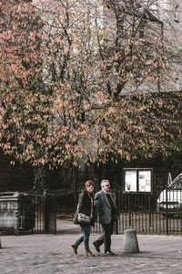 Man and woman standing by cherry blossom