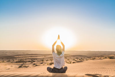 Woman doing yoga in desert