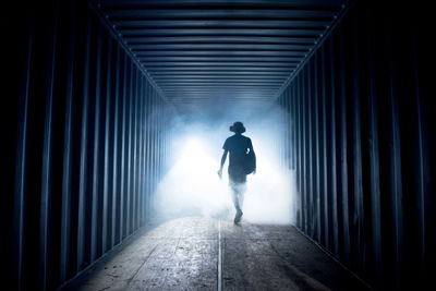 Silhouette of a man in a dark corridor. light at the end of the tunnel. moment of death concept