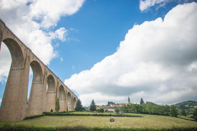 Low angle view of arch on field against sky