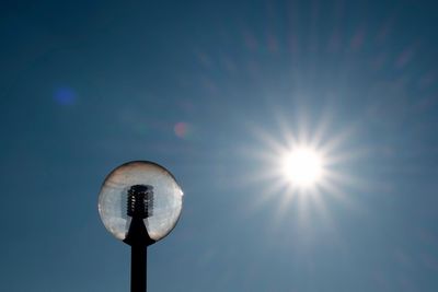 Low angle view of street light against blue sky