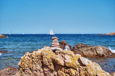 Close-up of rocks in sea against clear sky