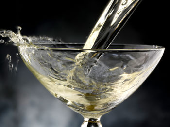 Close-up of wineglass on glass against white background