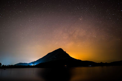 Scenic view of lake against sky at night